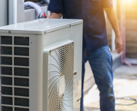 worker looking at a white box of an ac